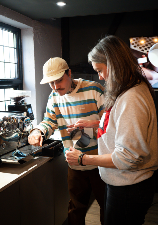 A student being taught to do latte art in 200 Degrees Beginner Barista course