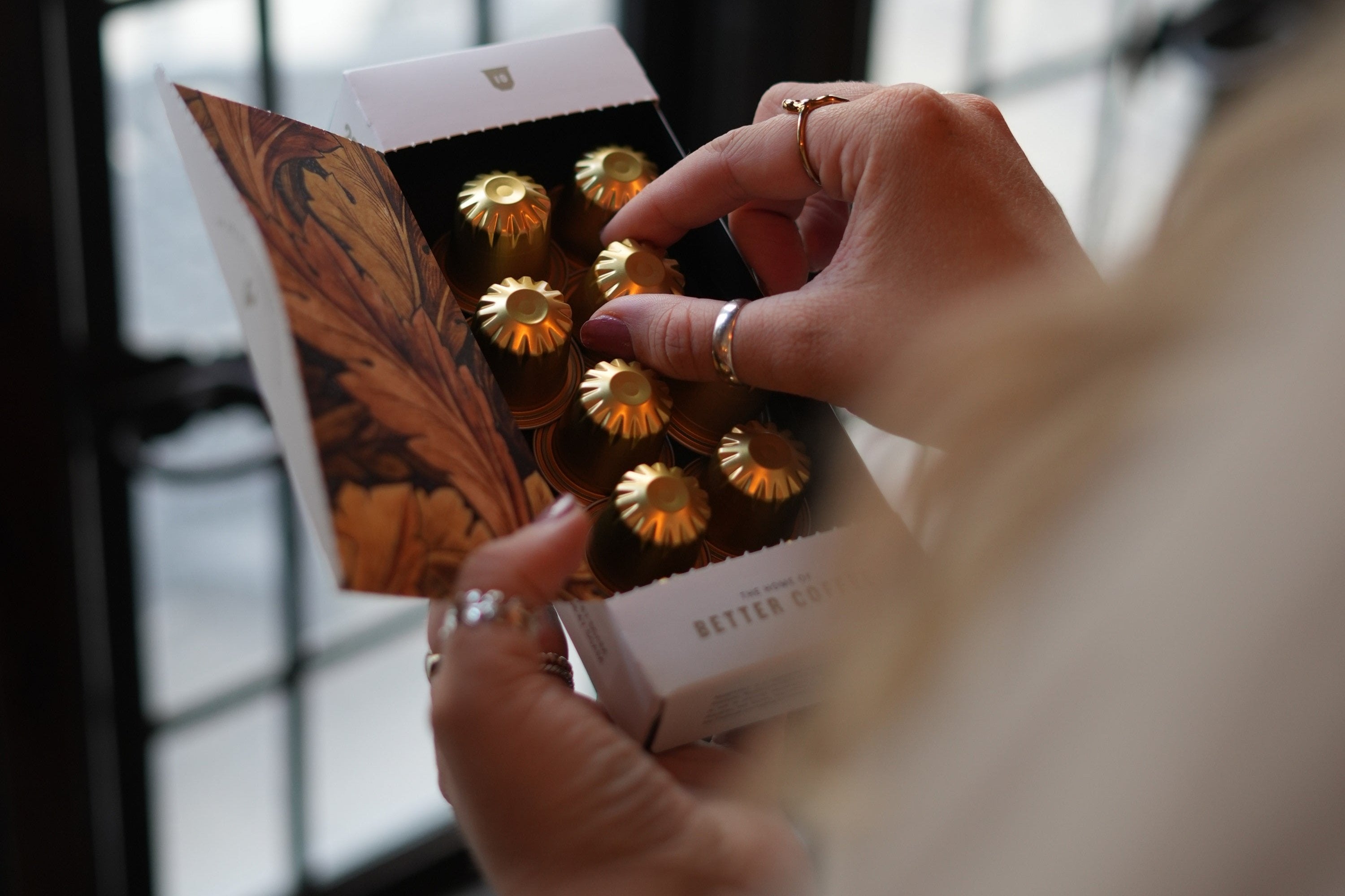 Picking a coffee pod from a Mellowship Slinky Decaf coffee pod box