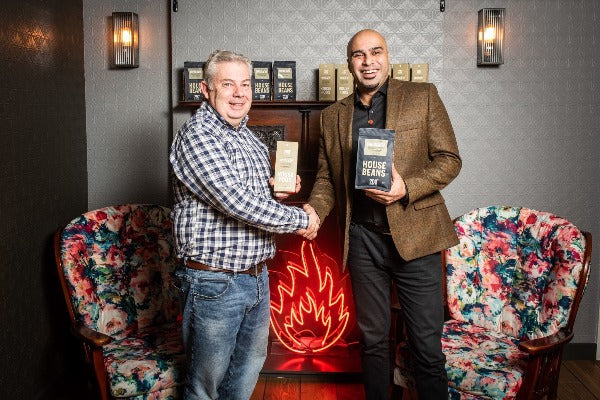Marcellus Baz and Roby Darby shaking hands with 200 degrees switch up charity coffee pods and beans