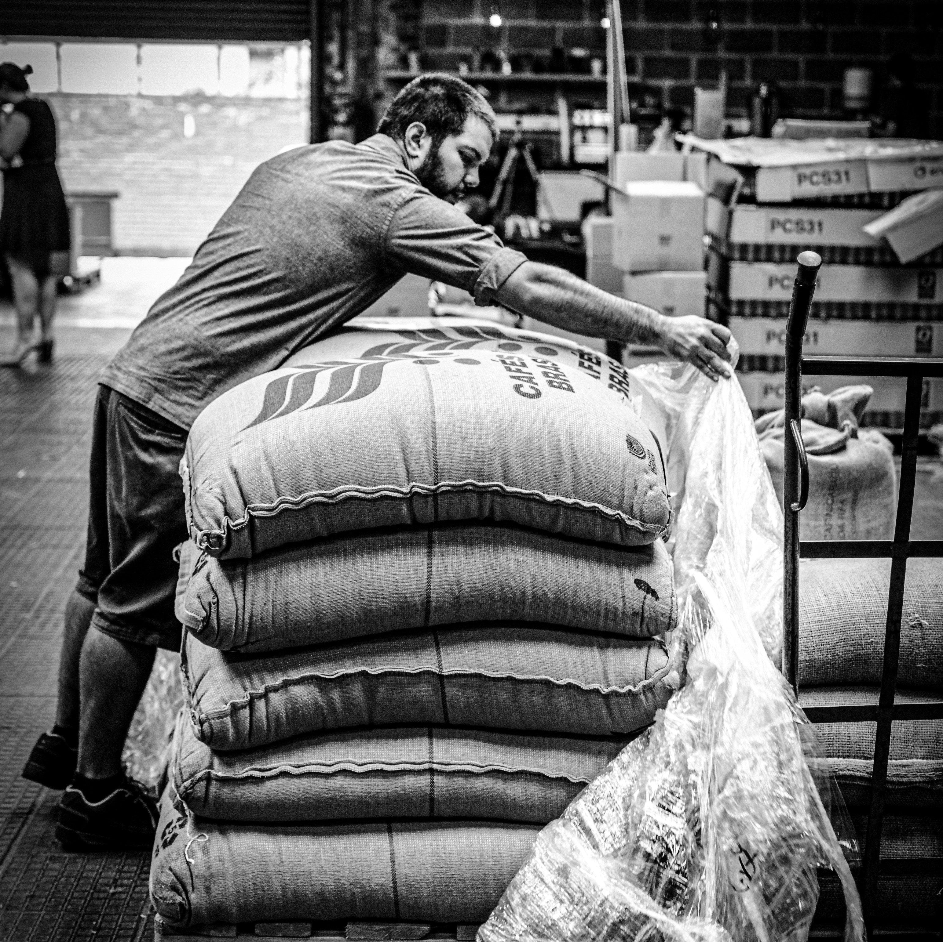Roast House team member sorting out some coffee bags